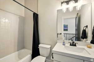 Bathroom featuring vanity, toilet, and shower / tub combo
