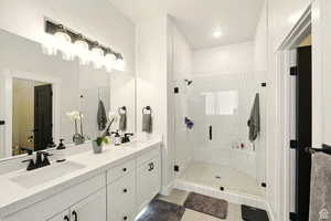 Large primary bathroom with double vanity, soaking tub, tile patterned floors, and walk-in closet