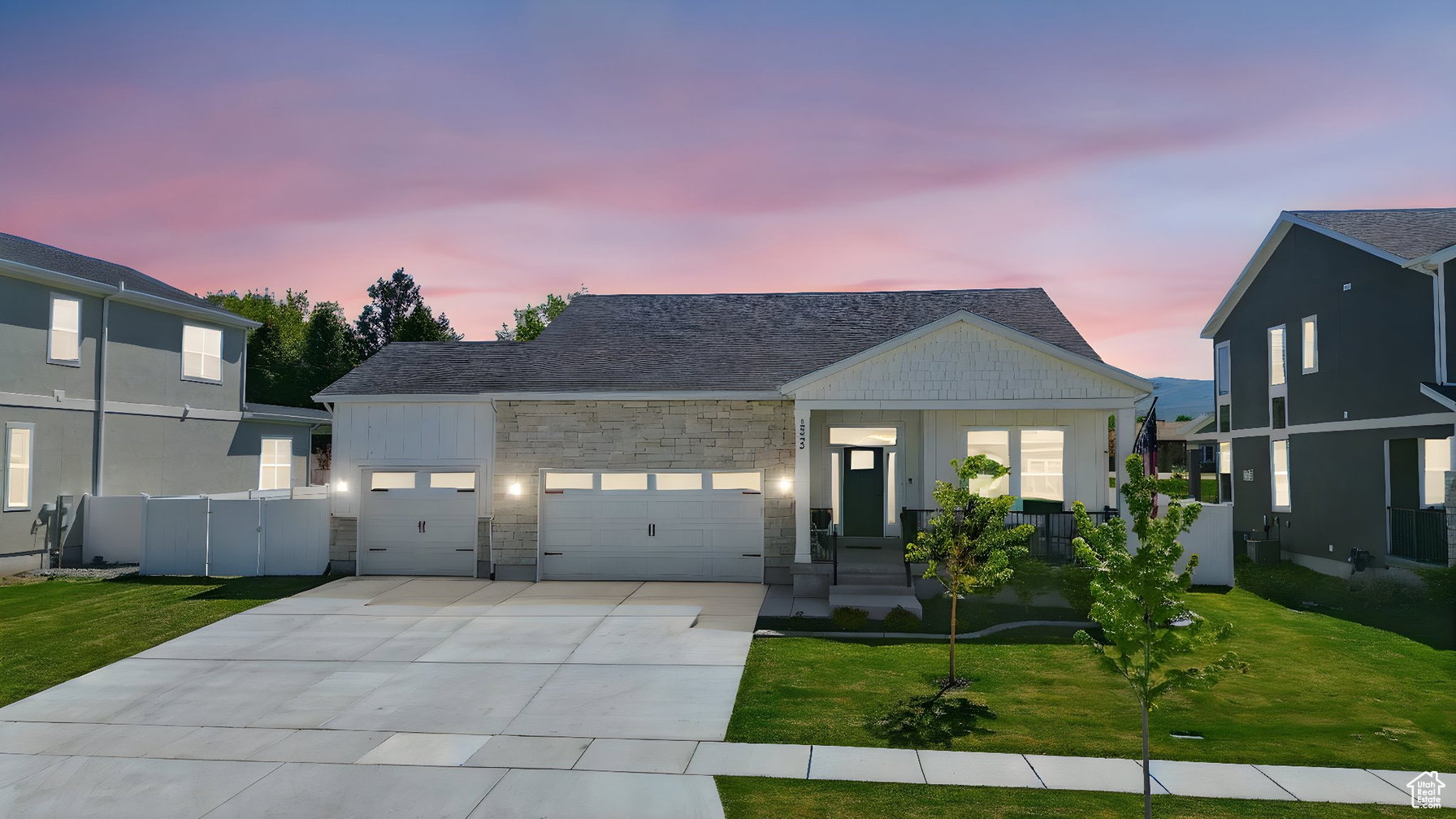 View of front facade with an attached garage, concrete driveway, and stone siding