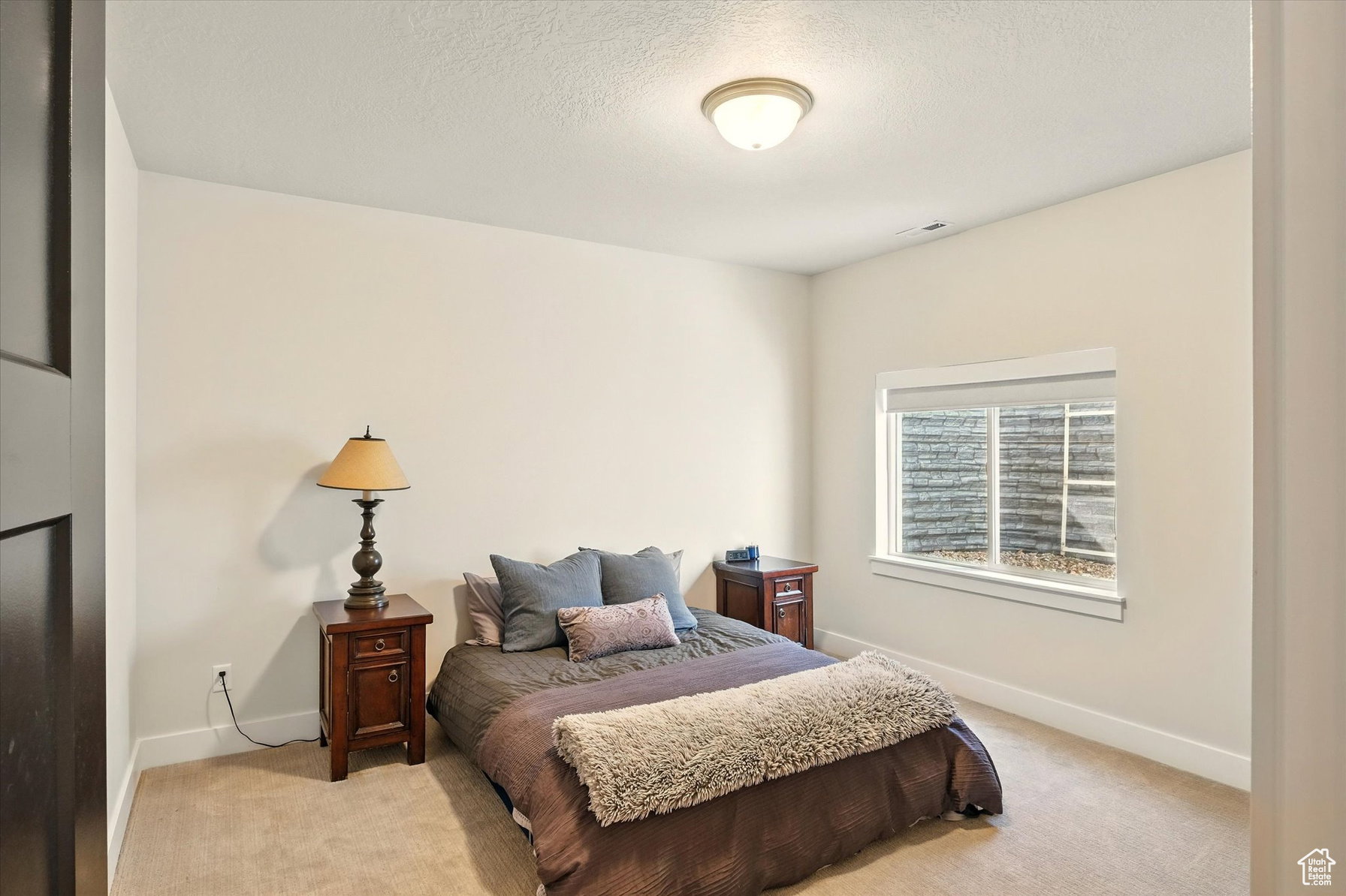 Large carpeted basement bedroom #1 and faux stone window well