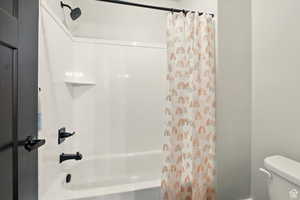 Full Jack & Jill basement bathroom featuring shower / bathtub combination and toilet