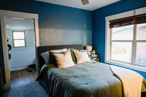Primary bedroom with wood finished floors and a ceiling fan