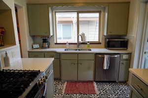 Kitchen featuring gray cabinets, decorative backsplash, and stainless steel appliances