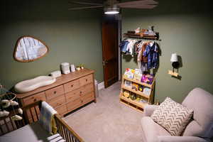 Carpeted bedroom featuring ceiling fan