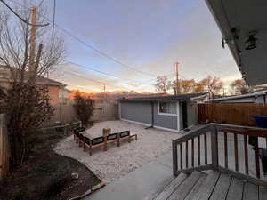 Fenced backyard featuring a patio and an outbuilding