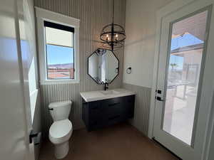 Bathroom with vanity, concrete floors, and hanging lights