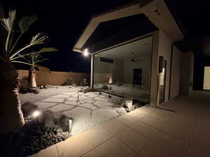 Patio at night featuring a patio, a fenced backyard, and ceiling fan