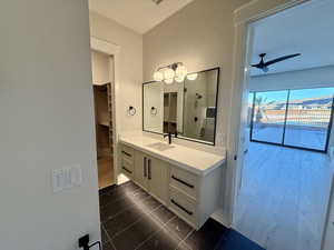 Full bathroom featuring vanity, ceiling fan, dark tile patterned flooring, a shower, and a spacious closet