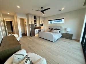 Bedroom featuring freestanding refrigerator, recessed lighting, light wood-style floors, a ceiling fan, and ensuite bath