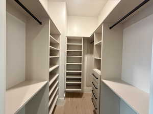 Walk in closet with light wood-style flooring