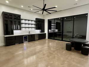 Indoor wet bar featuring dark cabinetry, open shelves, concrete flooring, glass insert cabinets, and recessed lighting