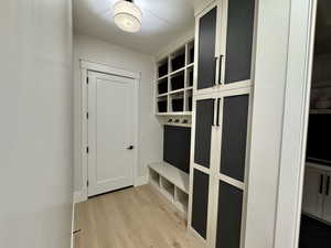 Mudroom featuring light wood-style flooring and baseboards