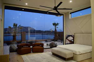 Bedroom featuring hardwood / wood-style flooring, floor to ceiling windows, and ceiling fan