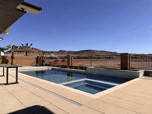 Relaxing pool / spa with a fenced backyard, a patio, and a mountain view