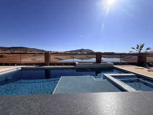 View of pool featuring a fenced backyard, an in-ground hot tub, and a mountain view