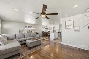 Living room with dark wood-style floors, a textured ceiling, a ceiling fan, and recessed lighting