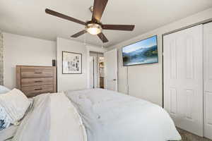Bedroom featuring a closet, a ceiling fan, and carpet floors