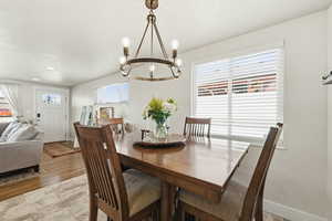 Dining space with suspended lighting and light wood-style flooring