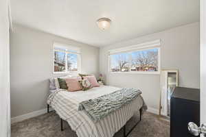 Carpeted bedroom with baseboards and a textured ceiling