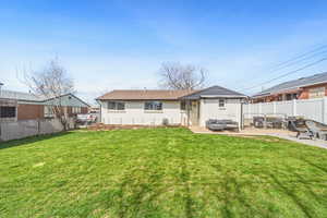 Rear view of property featuring a fenced backyard, a patio area, an outdoor lounge area, and brick siding