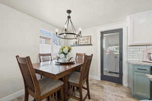Dining room with light stone finish flooring and suspended lighting