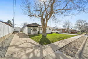 View of front of house with concrete driveway, a residential view, and an outdoor structure