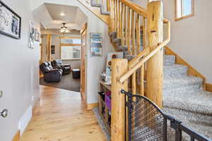 Stairs with hardwood / wood-style flooring and ceiling fan