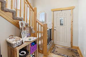 Foyer with stairs and light wood finished floors