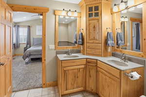 Primary Bathroom Ensuite, featuring double vanity, light colored carpet, ensuite bathroom, light tile patterned floors, and vaulted ceiling