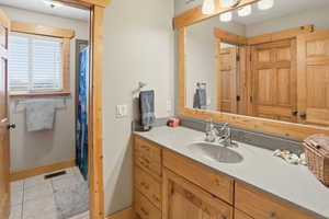 Full bathroom with vanity, a shower with a shower curtain, and light tile-patterned flooring
