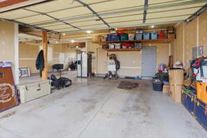 Attached Garage with stainless steel refrigerator with ice dispenser and electric panel