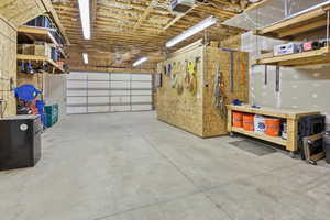 Garage featuring freestanding refrigerator, a garage door opener, and a workshop area