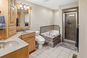 Primary bathroom ensuite with full bath, double vanity, a bath, a stall shower, light tile patterned floors, and recessed lighting