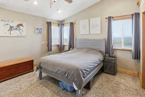 Primary Bedroom with lofted ceiling, light colored carpet, ceiling fan, and recessed lighting
