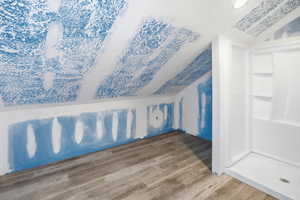 Spare room featuring lofted ceiling and wood finished floors