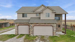 View of front of house featuring a shingled roof and stone siding