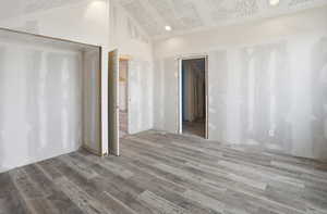 Unfurnished room featuring light wood-style flooring, recessed lighting, and vaulted ceiling