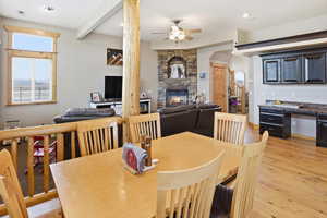 Dining area featuring light wood-style flooring, a fireplace, a ceiling fan, and recessed lighting