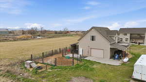 View of property exterior featuring an attached garage, roof with shingles, a patio area, and an outbuilding