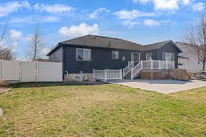 Back of property featuring a gate, a wooden deck, and roof with shingles