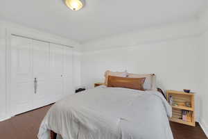 Bedroom featuring dark wood-type flooring, a closet, and ornamental molding