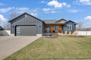 Ranch-style house featuring board and batten siding, a porch, an attached garage, and driveway