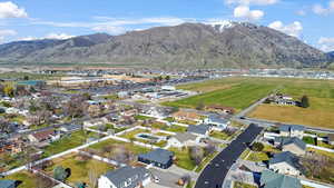 Aerial view of property and surrounding area with nearby suburban area and a mountainous background