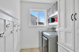 Laundry area with washing machine and clothes dryer and baseboards
