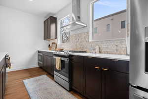 Perimeter quartz countertops with stainless steel hood, and northern windows for natural light.