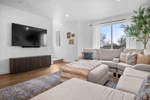 Spacious Great Room with LVP flooring, sectional, ottoman, and decorative rug.