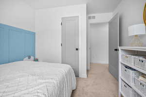 Bedroom with decorative wainscoting, large window for natural light, and walk in closet.