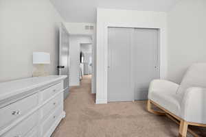 Bedroom with plush carpet, large window, and closet with built in shelving and cubbies.