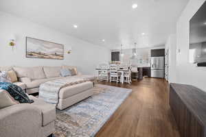 Spacious Great Room with LVP flooring, sectional, ottoman, and decorative rug.