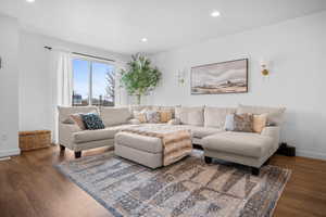 Spacious Great Room with LVP flooring, sectional, ottoman, and decorative rug.